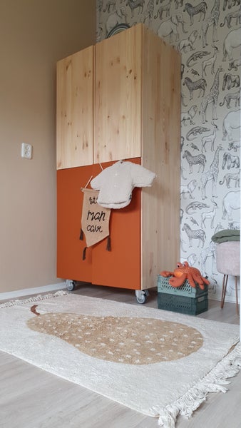 Kinderzimmer mit Holzschrank, Teppich und Spielzeug