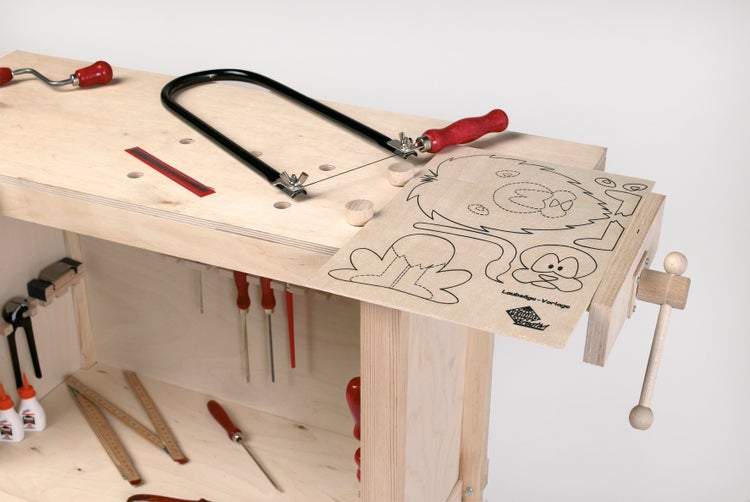 Werkbank aus Holz mit Laubsäge und Vorlage für Kinder, ausgestattet mit verschiedenen Werkzeugen im Innenraum.