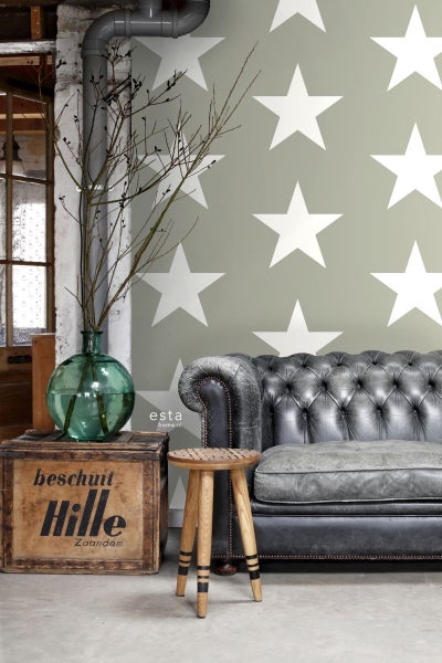 Vintage-Interieur mit Sofa, Hocker und Wandtapete mit Sternenmuster