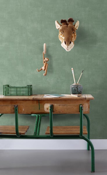 Dekoratives Kinderzimmer mit Schulbank, Giraffenkopf und Holzspielzeug vor einer Wand