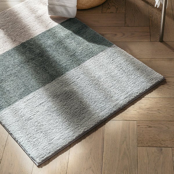 Rechteckiger Badteppich mit verschiedenen Farbflächen auf Holzboden