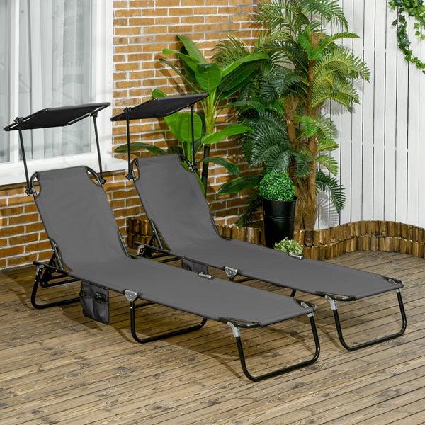 Zwei Gartenliegen mit verstellbarem Sonnendach und Metallgestell auf einer Holzterrasse, umgeben von Pflanzen.