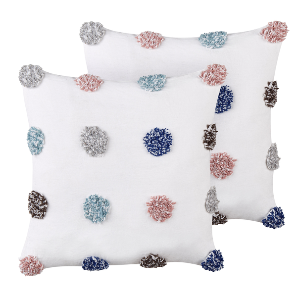 Zwei weiße Kissen mit dekorativen Bommeln