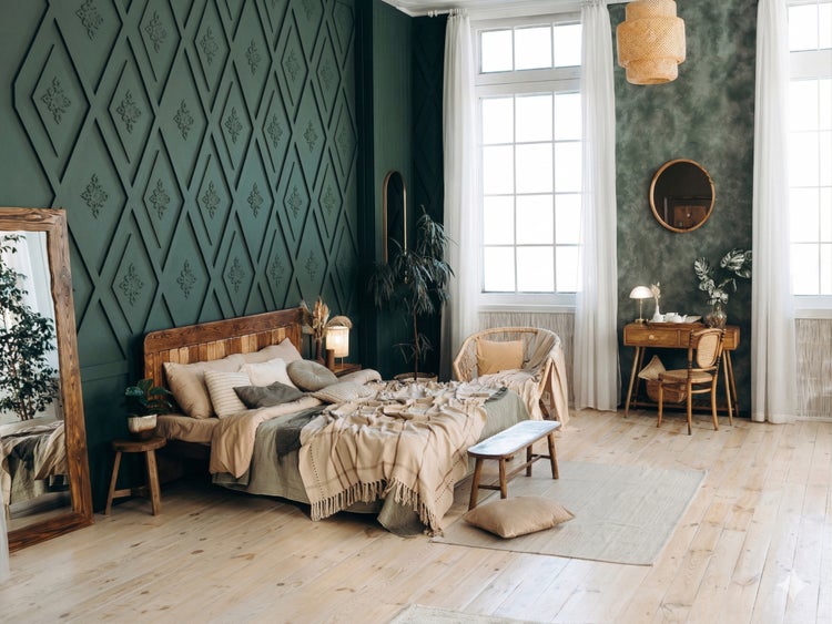 Geräumiges Schlafzimmer mit grünem Wandpaneel in Rautenoptik, Holzbett, großem Standspiegel und hellem Holzboden.