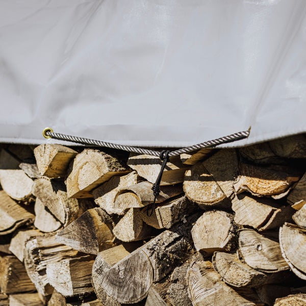 Holzstapel mit Abdeckplane und Seil zur Befestigung
