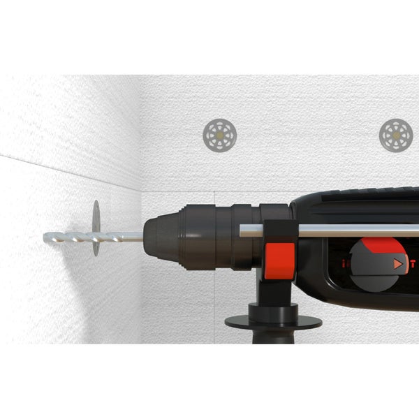 Bohrmaschine beim Bohren in eine Wand mit Dämmstoffdübeln