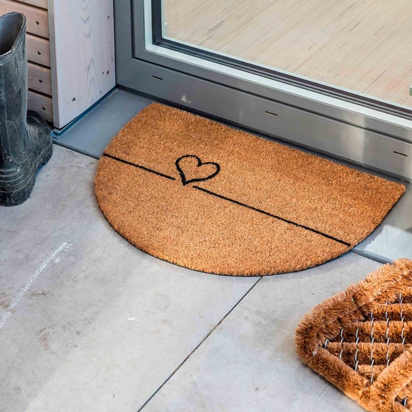 Halbrunde Fußmatte aus Kokosfaser mit Herzdesign vor einer Tür