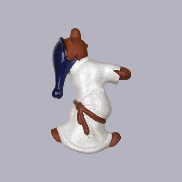 Dekorative Keramikfigur eines Schlafwandlers in weißem Gewand und blauer Zipfelmütze.