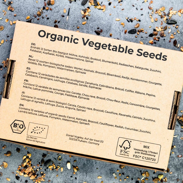 Pappschachtel mit 12 Sorten Bio-Gemüsesaatgut wie Möhre und Brokkoli, mit Bio-Siegel, Logo der Europäischen Union für Bioprodukte und FSC Logo.