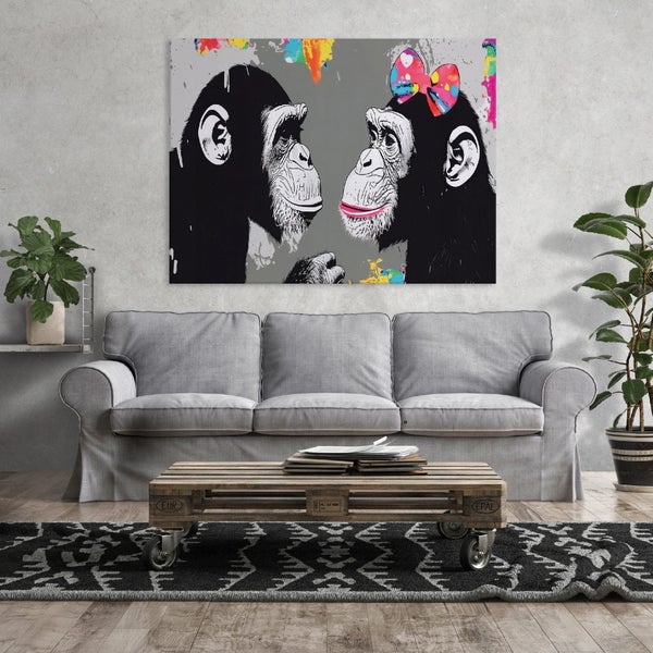 Wandbild mit zwei Schimpansen im Pop Art Stil über einem grauen Sofa mit einem Palettentisch in einem modern eingerichteten Wohnzimmer.