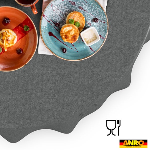 Graue Tischdecke mit Stoffstruktur auf einem gedeckten Tisch. Lebensmittelecht Symbol und ANRO Deutsche Manufaktur Logo.