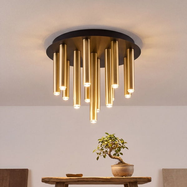Moderne Deckenleuchte mit runder schwarzer Basis und goldfarbenen Metallzylindern in verschiedenen Längen.
