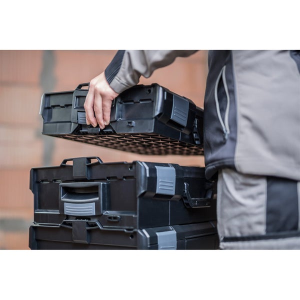 Person verlegt Bitumenschweißbahn auf einem Flachdach mit einem Gasbrenner.