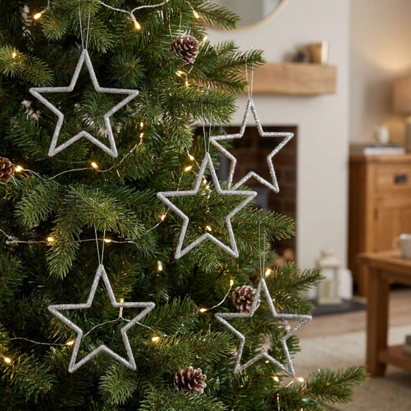 Weihnachtsbaum mit glitzernden Sternen Anhängern und Lichterkette als festliche Dekoration