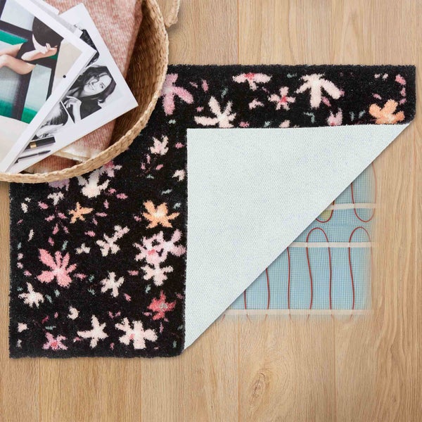 Blumiger Teppich mit freiliegender Rückseite auf Holzboden