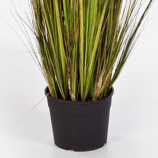 Künstliches Ziergras in einem schwarzen Kunststofftopf.