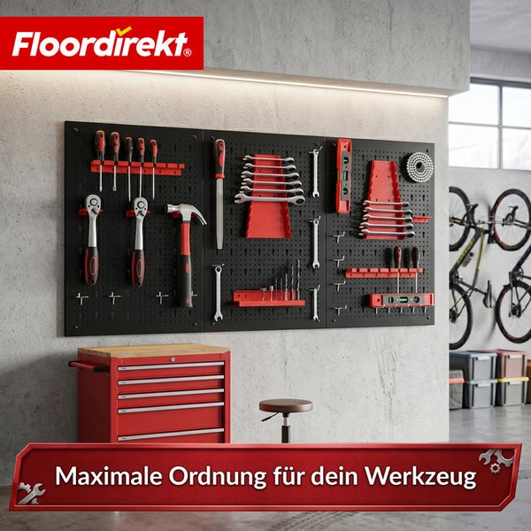 Schwarze Lochwand zur Werkzeugaufbewahrung mit Handwerkzeugen an einer hellen Wand, daneben ein roter Werkzeugwagen und das Floordirekt Logo.