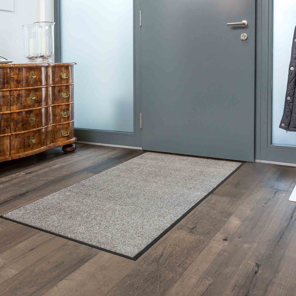 Eingangsbereich mit Fußmatte, Kommode und Tür