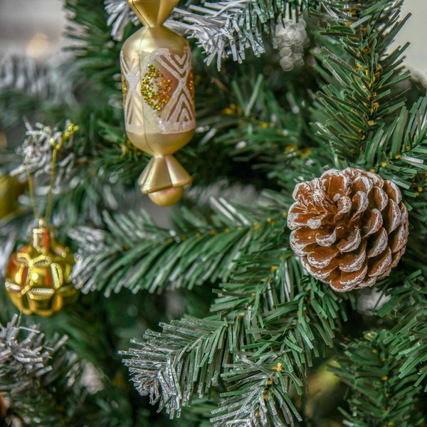 Künstlicher Weihnachtsbaum mit grünen Zweigen, geschmückt mit einem Tannenzapfen und goldenen Anhängern in Bonbonform.