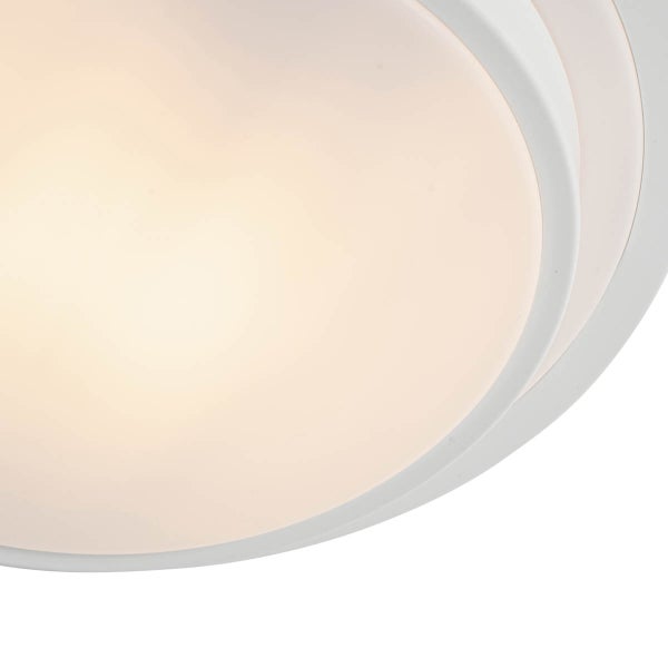 Runde Deckenleuchte mit weißen Ringen und warmweißem Lichtschein durch die Abdeckung.