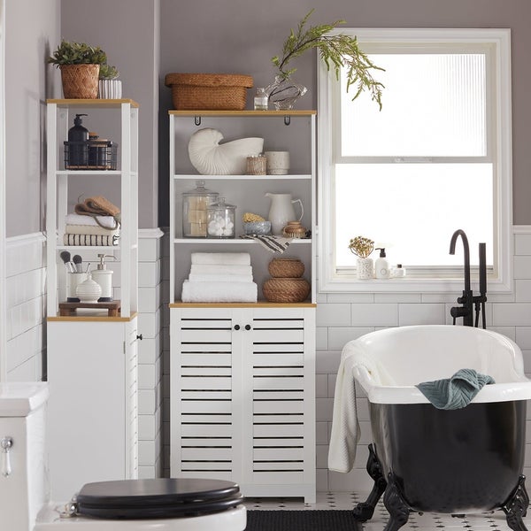 Badezimmer mit freistehender Badewanne, Waschbecken und Badezimmermöbeln zur Aufbewahrung