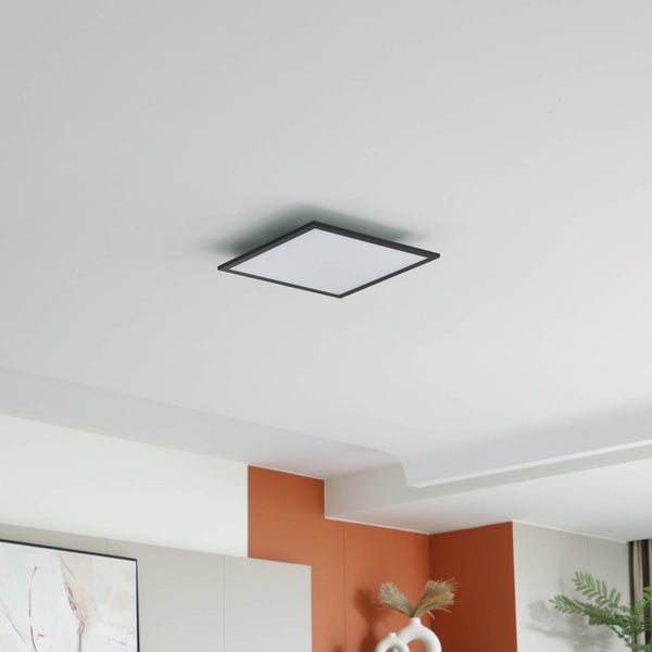 Quadratisches, ultraflaches LED-Panel mit schmalem schwarzem Rahmen, montiert an einer weißen Decke in einem modern gestalteten Raum.