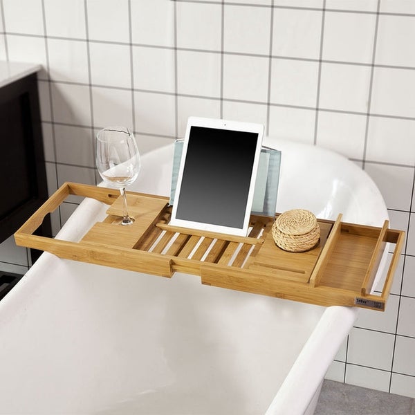 Badewannenablage mit Tablet, Weinglas und Dekoration auf einer Badewanne