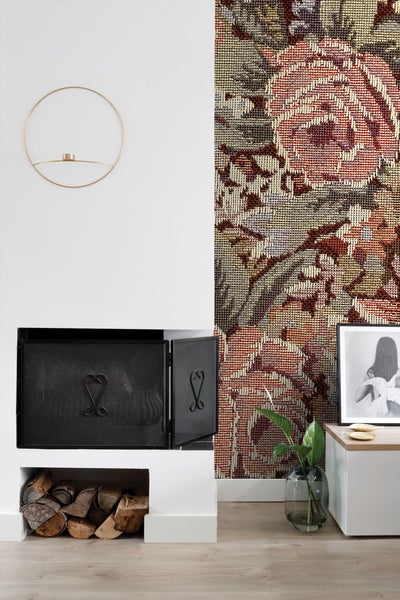 Wohnzimmer mit Kamin, Holzlagerung, Wandteppich und Dekoration