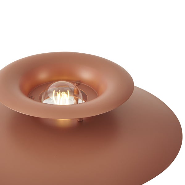 Nahaufnahme eines runden Lampenschirms aus Metall in Terrakotta mit einem sichtbaren Leuchtmittel.