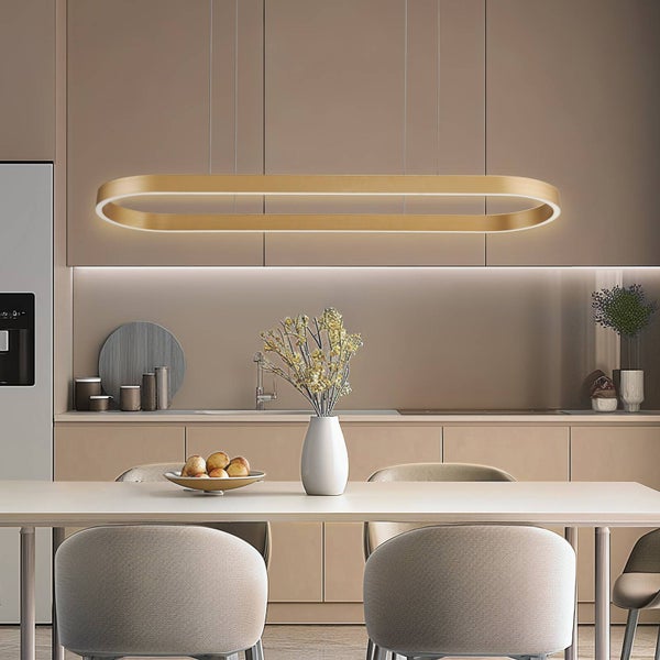 Moderne goldfarbene LED-Pendelleuchte in Ringform über einem Esstisch in einer minimalistischen Küche.