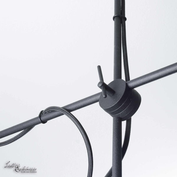 Detailansicht einer schwarzen Leuchte mit verstellbarem Gelenk und Kabel