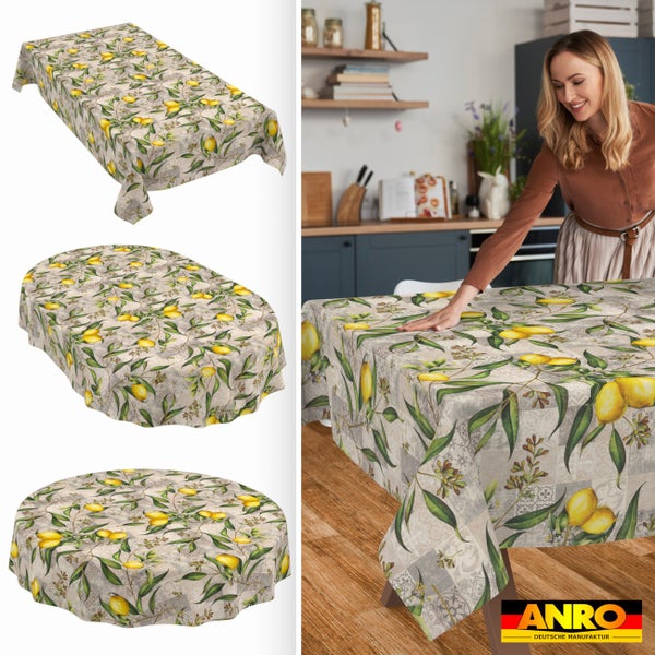 Tischdecke mit Zitronenmuster in verschiedenen Formen. Ansicht in einer hellen Küche auf einem Holztisch. ANRO Deutsche Manufaktur Logo.