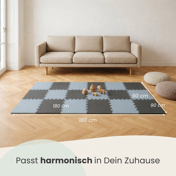 Modernes, helles Wohnzimmer mit Sofa, Parkettboden und einer blau-grauen Puzzlespielmatte aus Schaumstoff in den Maßen 180 mal 180 Zentimeter.