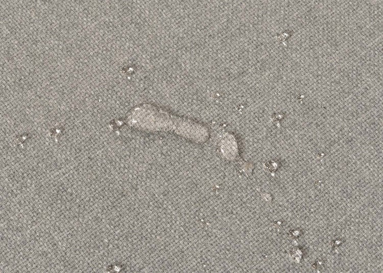 Nahaufnahme eines wasserabweisenden Stoffes mit Wassertropfen