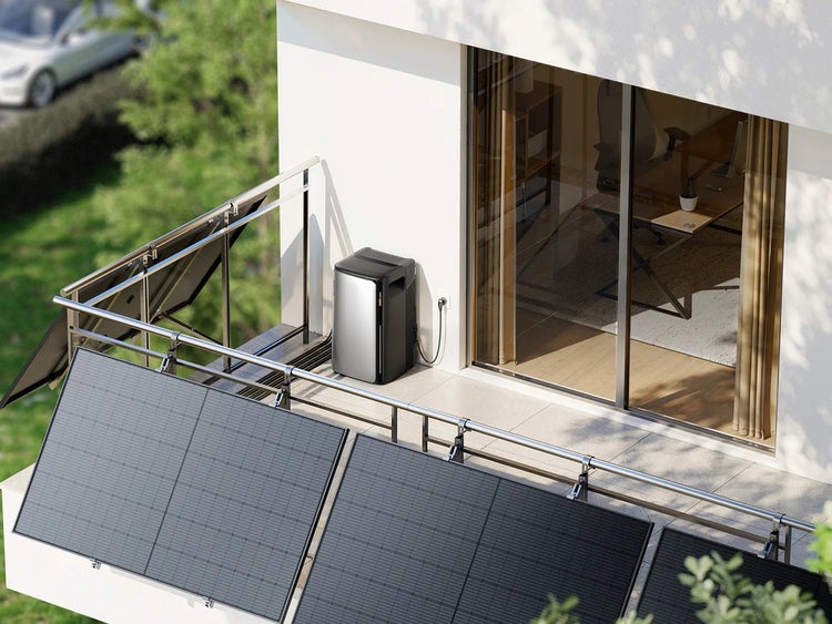 Balkonkraftwerk mit Solarmodulen am Metallgeländer und einem tragbaren Stromspeicher auf einem hellen, modernen Balkon.