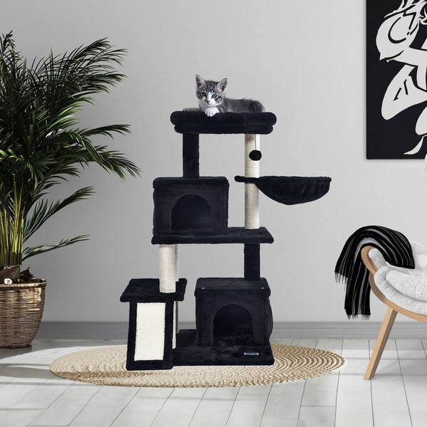 Kletterbaum für Katzen mit Liegeplätzen, Schlafhöhlen und Sisalsäulen zum Kratzen, aufgestellt in einem modernen Wohnraum mit einer Katze.