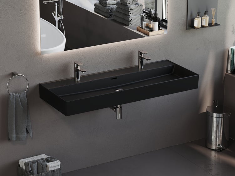 Modernes Badezimmer mit schwarzem Waschtisch und beleuchtetem Spiegel