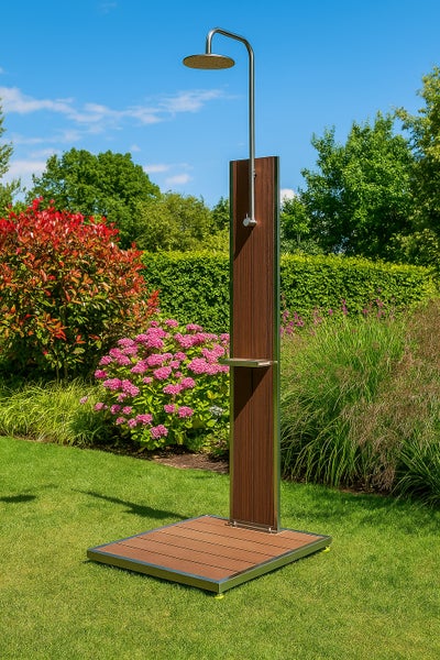 Freistehende Gartendusche mit Paneelen in Holzoptik und Edelstahlgestell, inklusive Bodenplatte und Ablage, in einem hellen Garten.