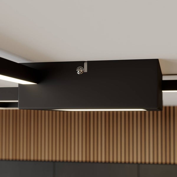 Schwarze LED-Deckenleuchte mit rechteckigem Sockel, montiert an der Decke vor einer Wand mit Holzlamellen.