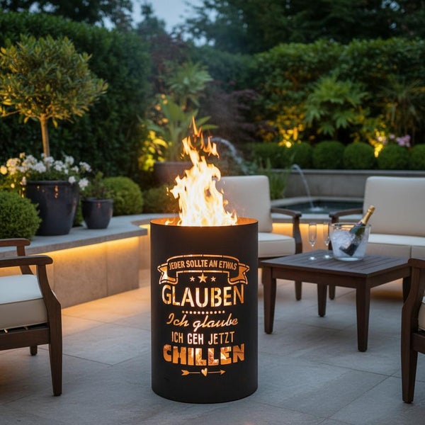 Feuersäule mit Flammen und Aussparungen mit dem Text 'Jeder sollte an etwas glauben. Ich glaube ich geh jetzt chillen' im Garten