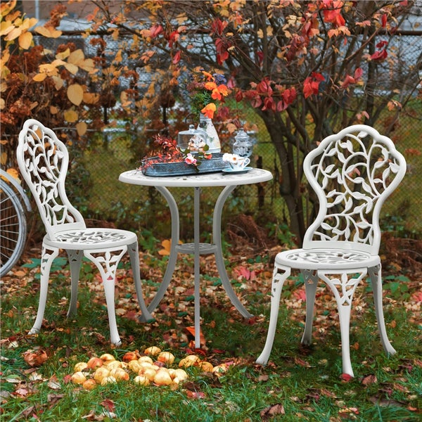 Gartenszene mit einem runden Tisch und zwei Stühlen im Freien mit Herbstlaub