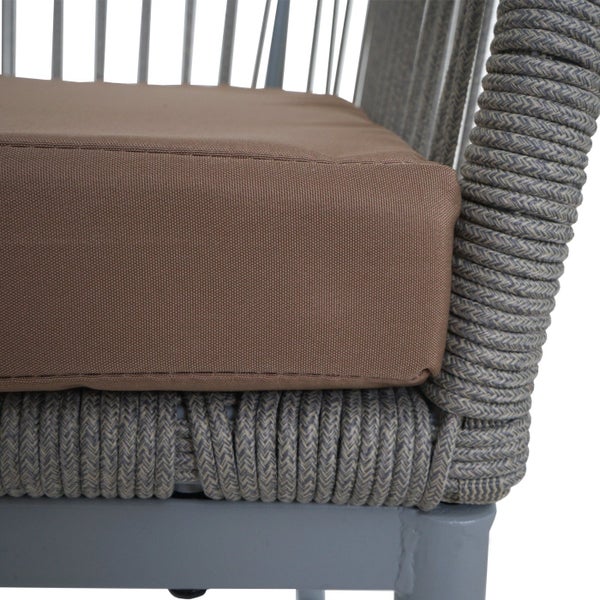 Detailansicht eines Outdoor-Sessels mit Sitzkissen und geflochtenem Rahmen