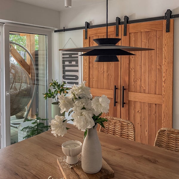 Innenraum mit Esstisch, Blumen, Hängelampe und Schiebetür im Landhausstil