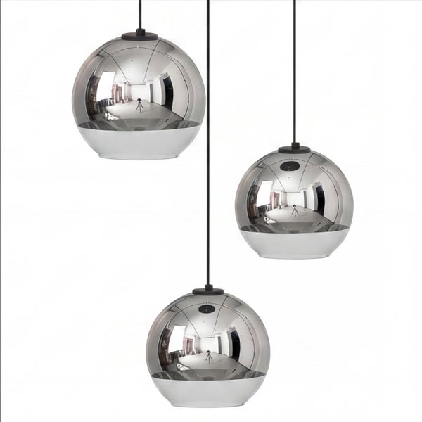 Dreiflammige Pendelleuchte mit kugelförmigen Glasschirmen, oben teilverspiegelt in Chrom-Optik und unten klar, an schwarzen Kabeln.