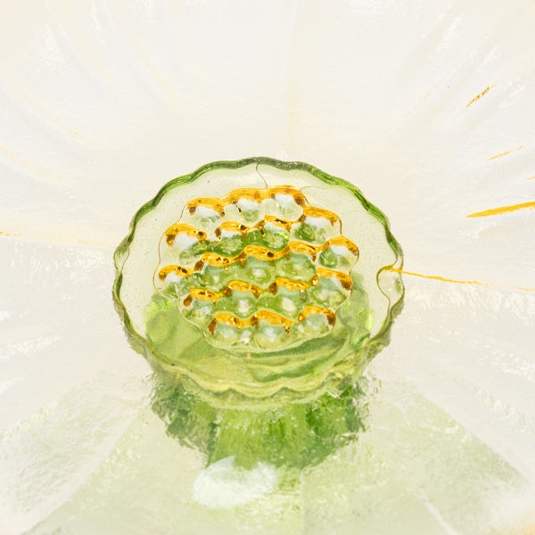 Nahaufnahme einer Glasblume mit grünen und goldenen Akzenten