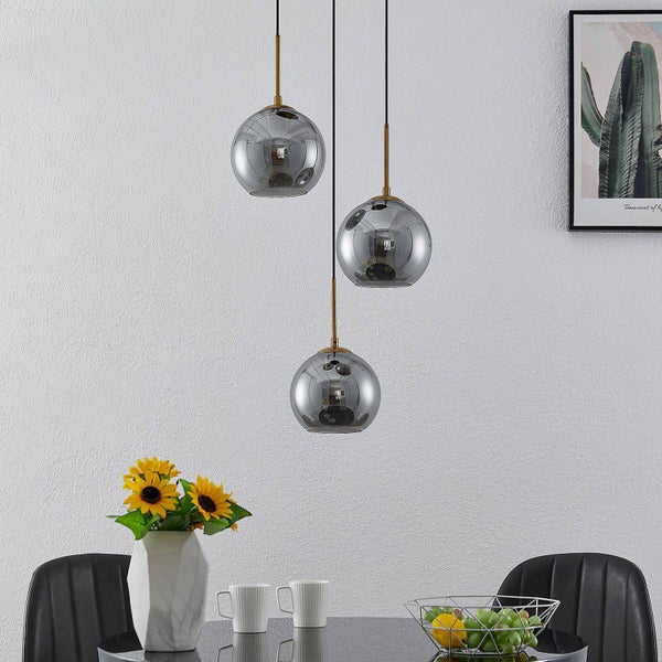 Esstisch mit drei grauen Hängeleuchten in Kugelform