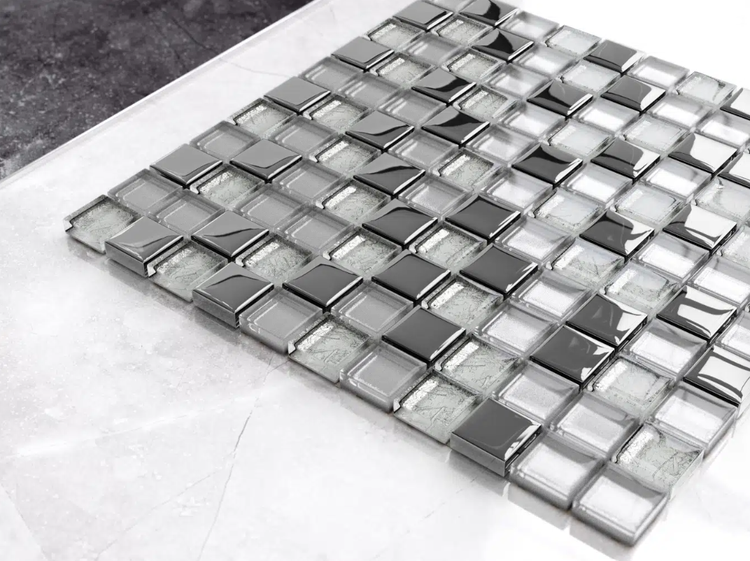 Mosaikfliese aus Glas und Metall mit quadratischen Steinen in glänzender und strukturierter Optik.