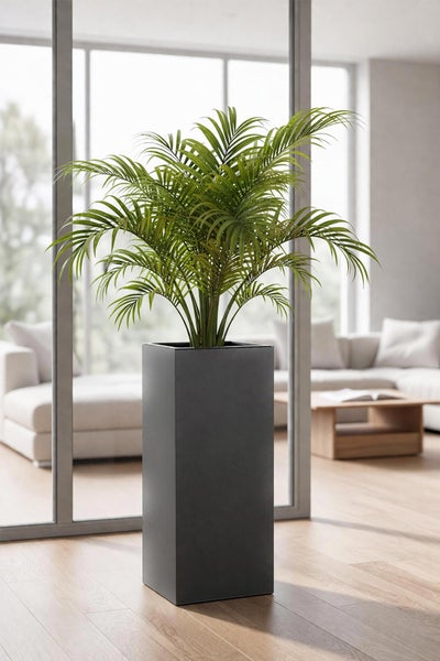 Hoher, anthrazitfarbener Pflanzkübel mit einer Palme in einem hellen, modernen Wohnzimmer mit großen Fenstern.