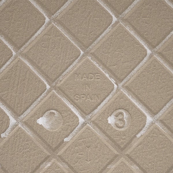 Die Rückseite einer Keramikfliese mit gitterförmigem Profil und dem eingeprägten Schriftzug Made in Spain.