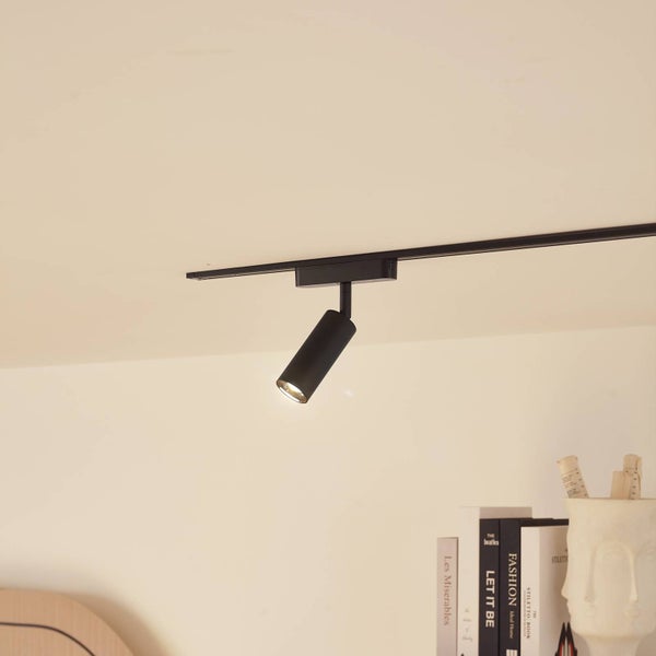 Schwarzer zylindrischer Strahler an einem Schienensystem, montiert an der Decke, modernes Design.
